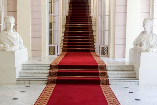 Majestic entrance with red carpet and statues at Albertina Museum in Vienna.