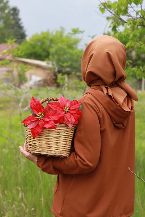 Woman Wearing Headscarf Holding a Basket with Flowers 