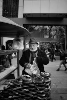 Charming street vendor selling traditional Turkish simit in a bustling Ankara marketplace.