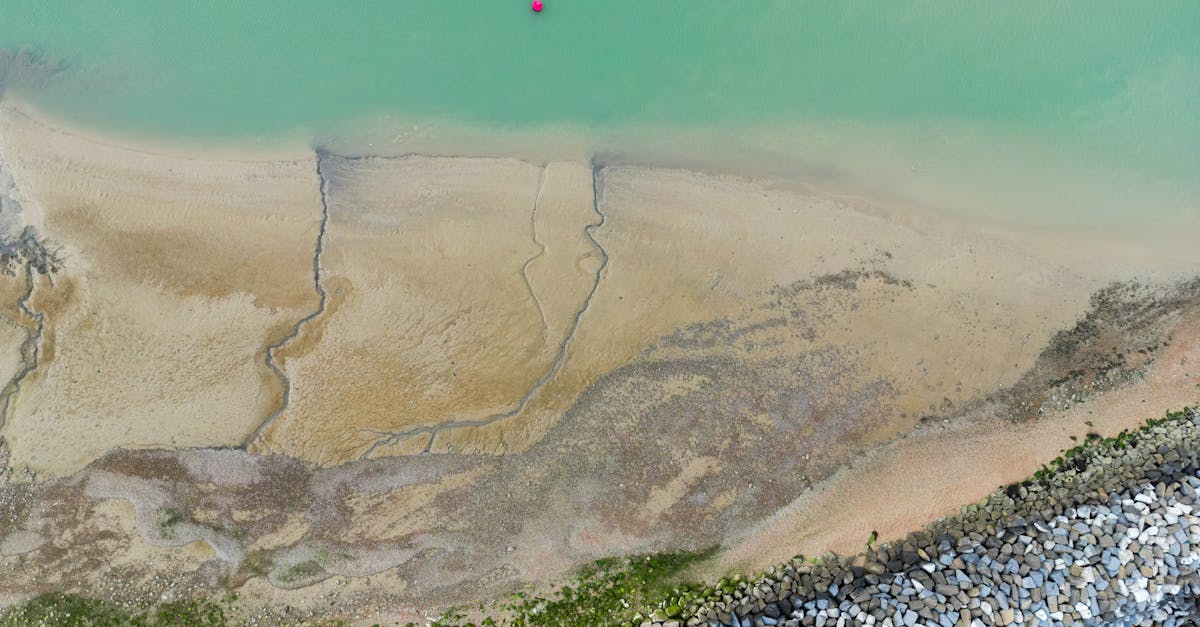 Aerial shot of the serene coastline at Eastbourne, England, featuring turquoise waters and sandy shores.