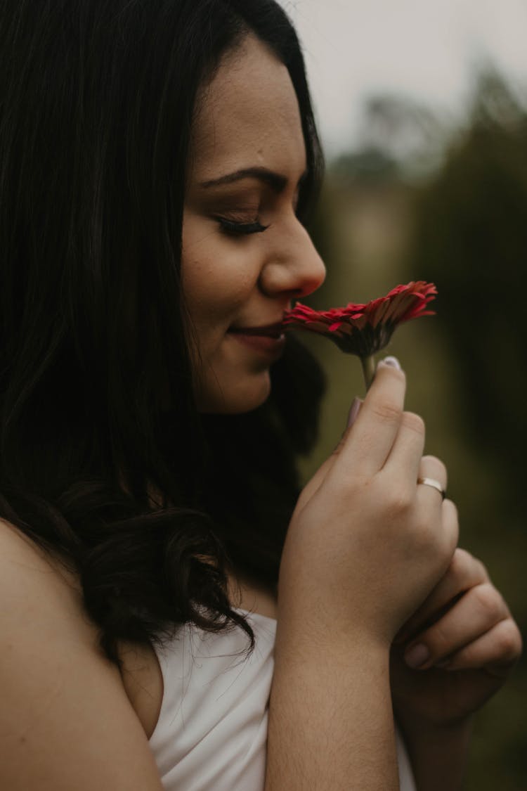 Woman Smelling Red Flower