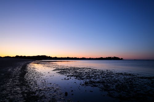 View of an Empty Beach and Sunset Reflecting in the Water 