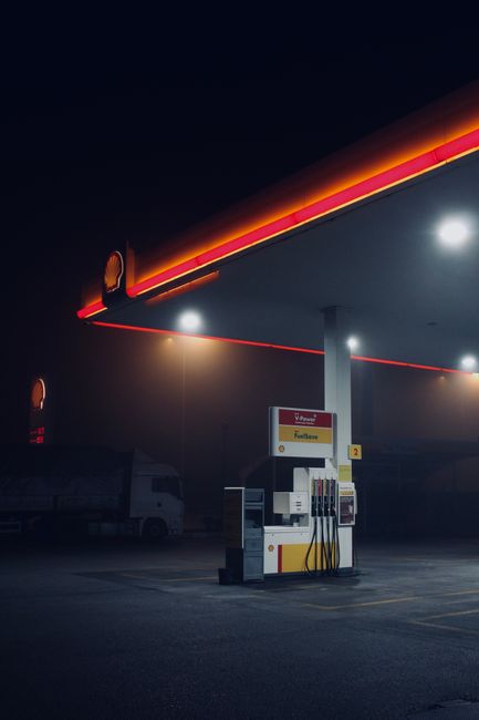 Moody nighttime scene of a gas station in Ankara, Türkiye, highlighting its illuminated structure.