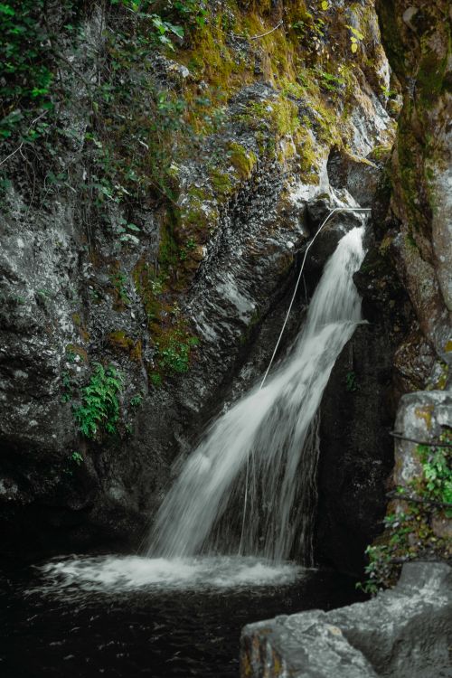Free A picturesque waterfall cascades through rocky cliffs in Camaiore, Tuscany, Italy. Stock Photo