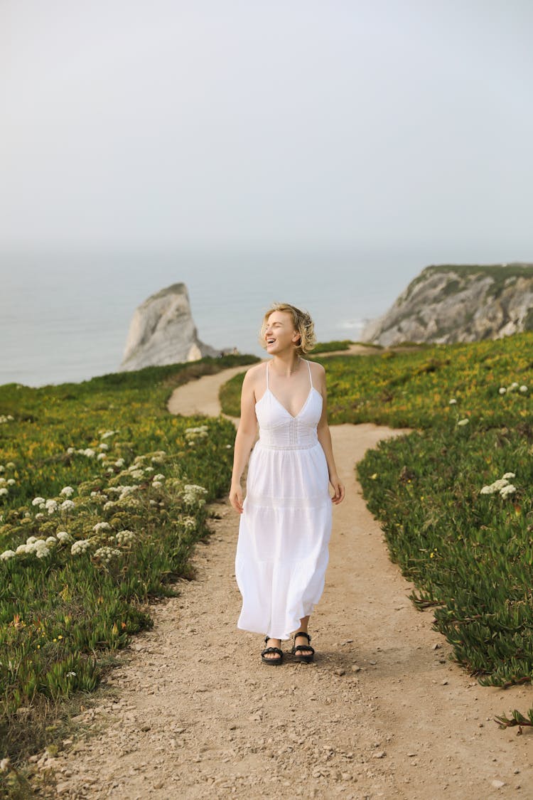 Smiling Woman Walking On Path In Countryside