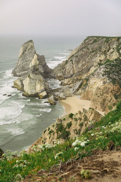 Free Breathtaking view of dramatic cliffs and a secluded beach with ocean waves. Stock Photo