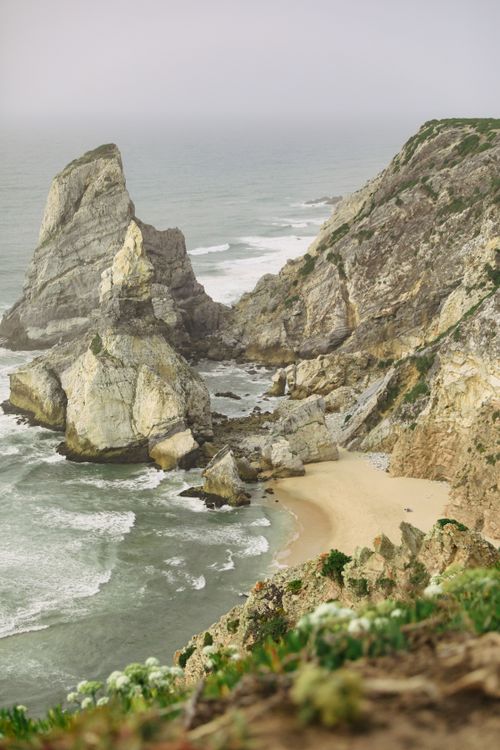 Free Discover the dramatic rock formations and serene sandy beach of Ursa Beach, Portugal's coastal gem. Stock Photo
