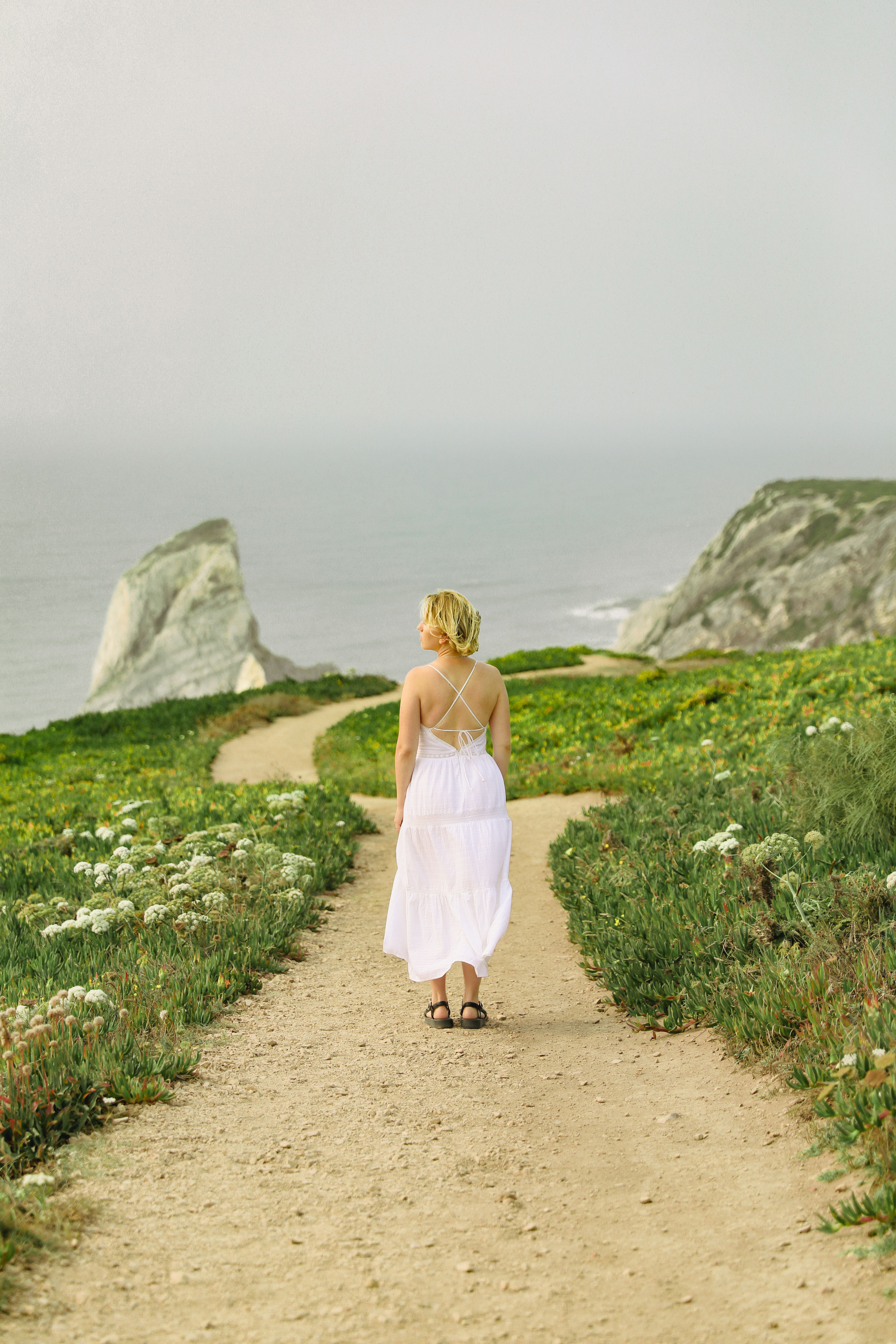 Woman Walking on Path on Rocky Seashore · Free Stock Photo