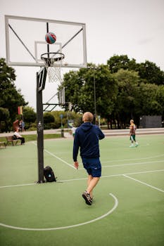 A man playing basketball on an outdoor court captures active leisure and sport.