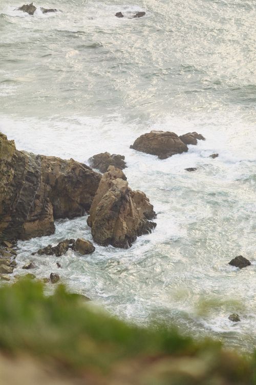 Free Stunning aerial view of rocky coastline with foamy ocean waves crashing against the shore. Stock Photo