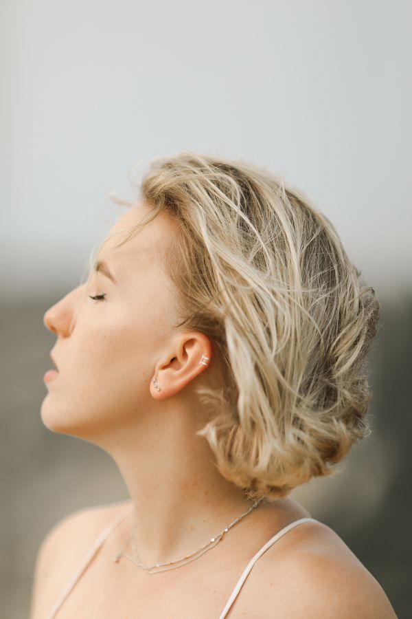 Woman calmly breathing in fresh air, eyes closed in soft light