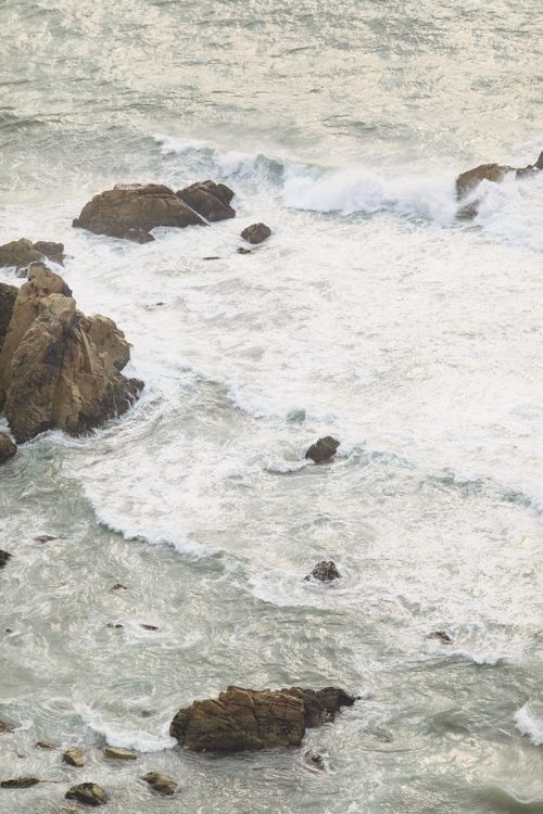 Free Waves and rocks create a dynamic seascape, capturing oceanic power and beauty. Stock Photo