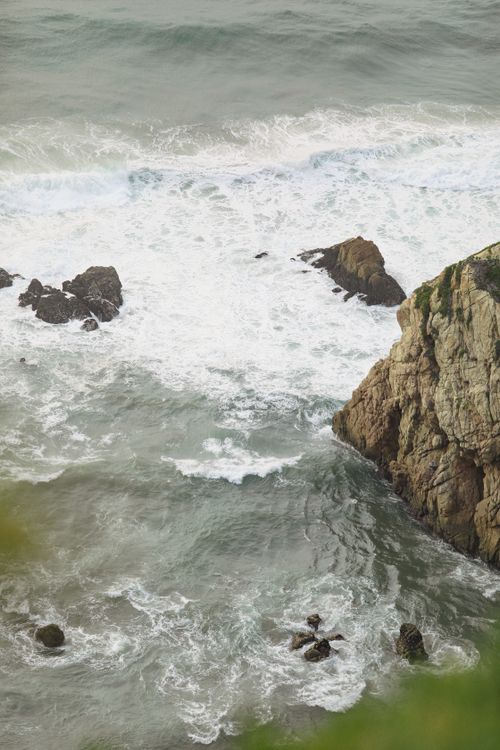 Free High-angle view of ocean waves crashing against rocky cliffs at Ursa Beach, Portugal. Stock Photo