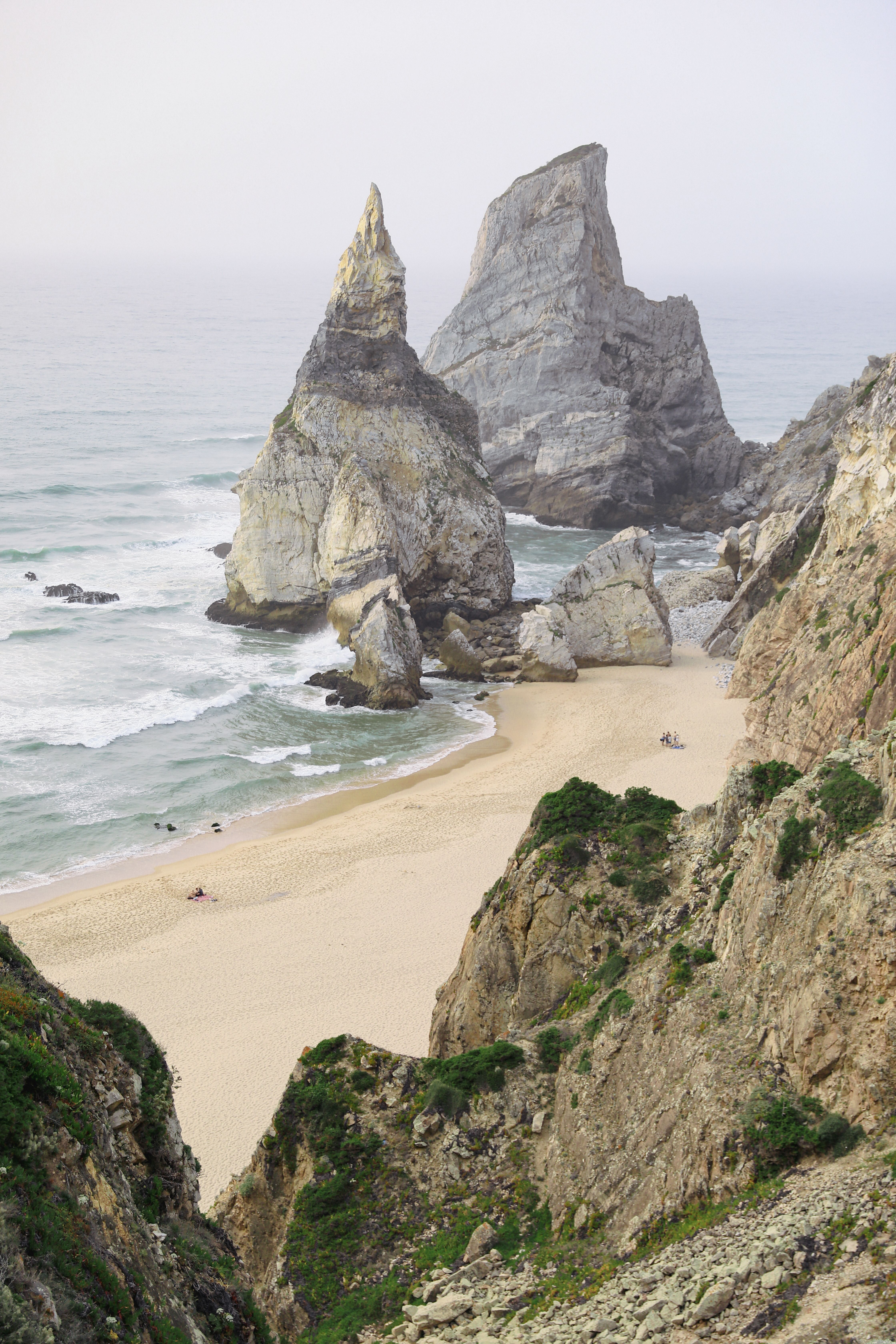 A beach with rocks and sand near the ocean · Free Stock Photo