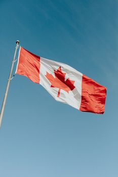 A Canadian flag waving gracefully against a clear blue sky in Dartmouth, NS.