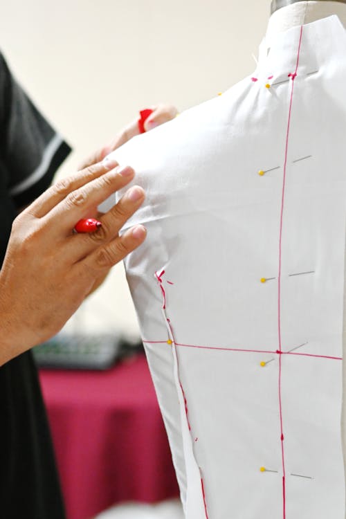 Hands Touching White Clothes on Mannequin