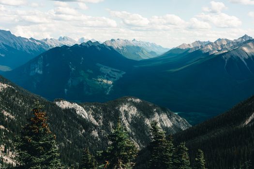 Stunning panoramic view of the Canadian Rockies in Banff National Park, showcasing lush valleys and steep peaks.