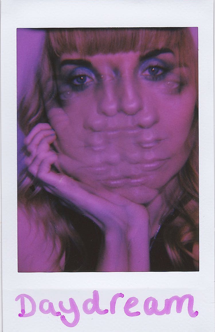 Polaroid Photo With A Composite Female Face And A Text