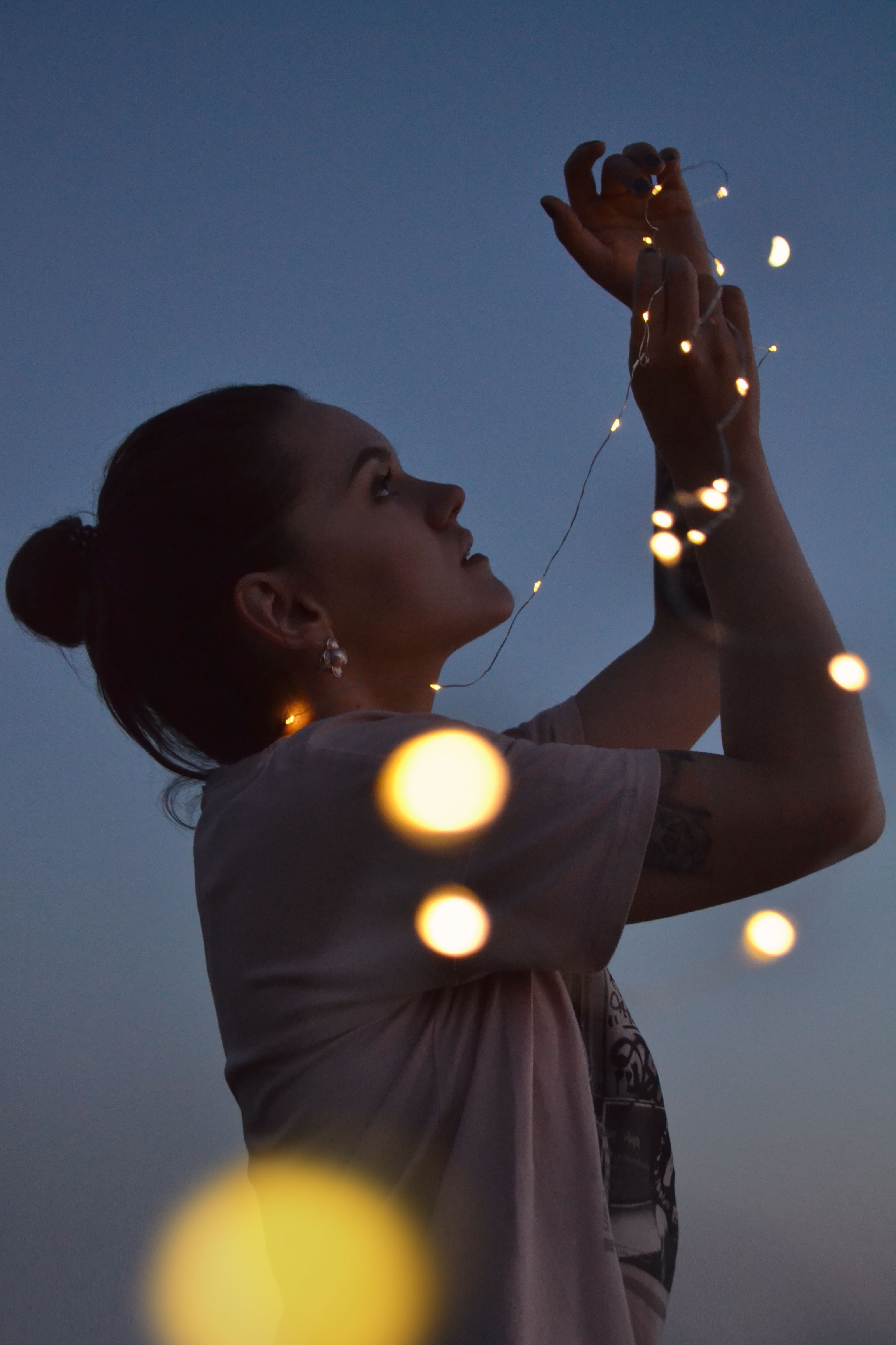 Woman Holding Lights at Dusk · Free Stock Photo