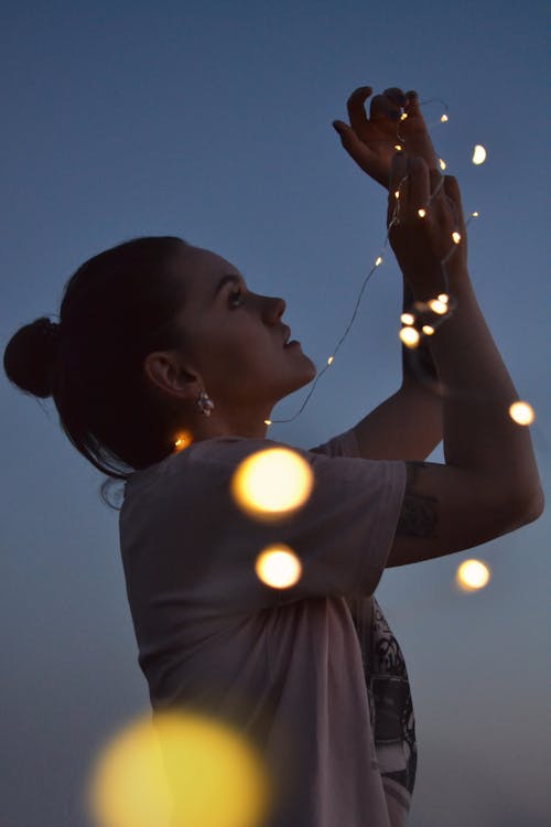 Silhouette Photo of Woman Holding Lights · Free Stock Photo