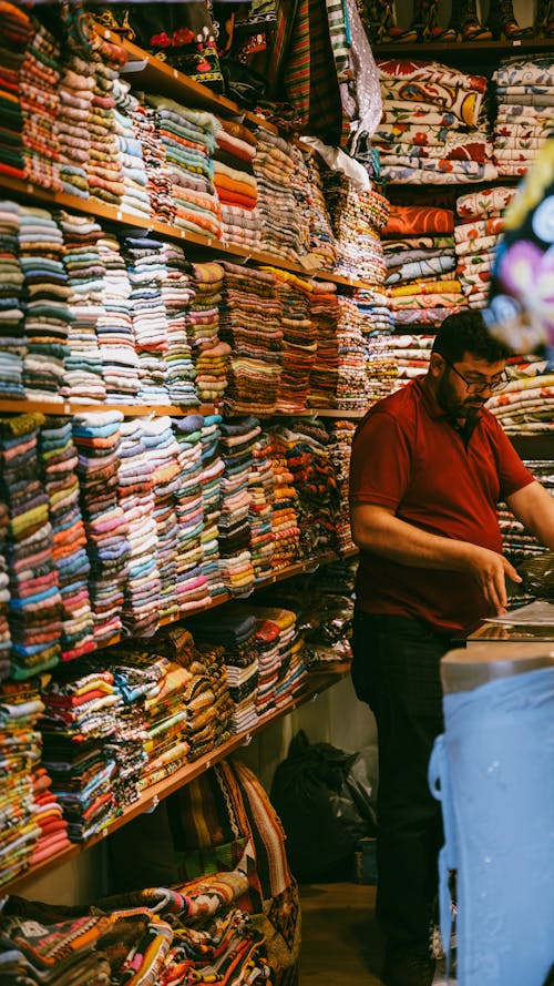 A Man Working in the Shop with a Variety of Fabrics 