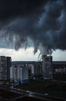 A dramatic cityscape with towering storm clouds looming over urban buildings.