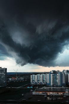 A dramatic cityscape captured under dark, ominous storm clouds, showcasing urban architecture.