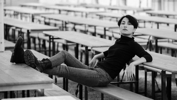 Woman in Polo Neck Sweater, Jeans and Combat Boots Posing in a Street Cafe