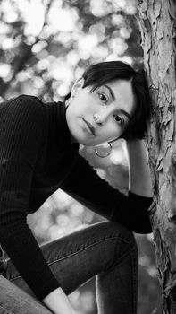 Artistic soft portrait of a woman in a turtleneck outdoors in black and white.