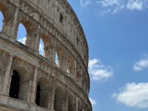 Free A majestic view of the Roman Colosseum under a bright blue summer sky. Stock Photo