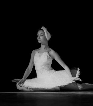 Elegant ballerina performing in a classic black and white stage setting.