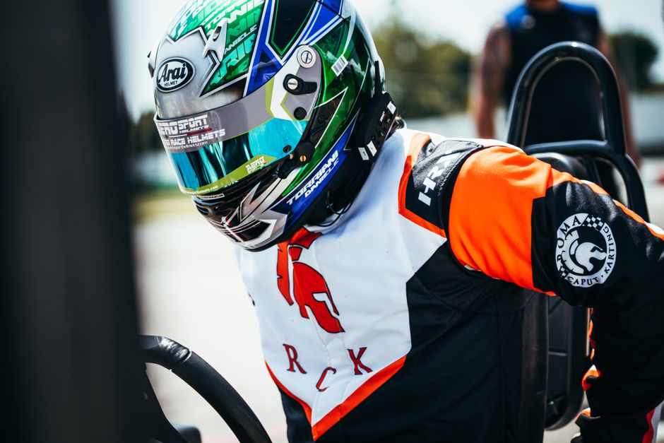 Close-up of a racer wearing a helmet and suit ready for action on the track.