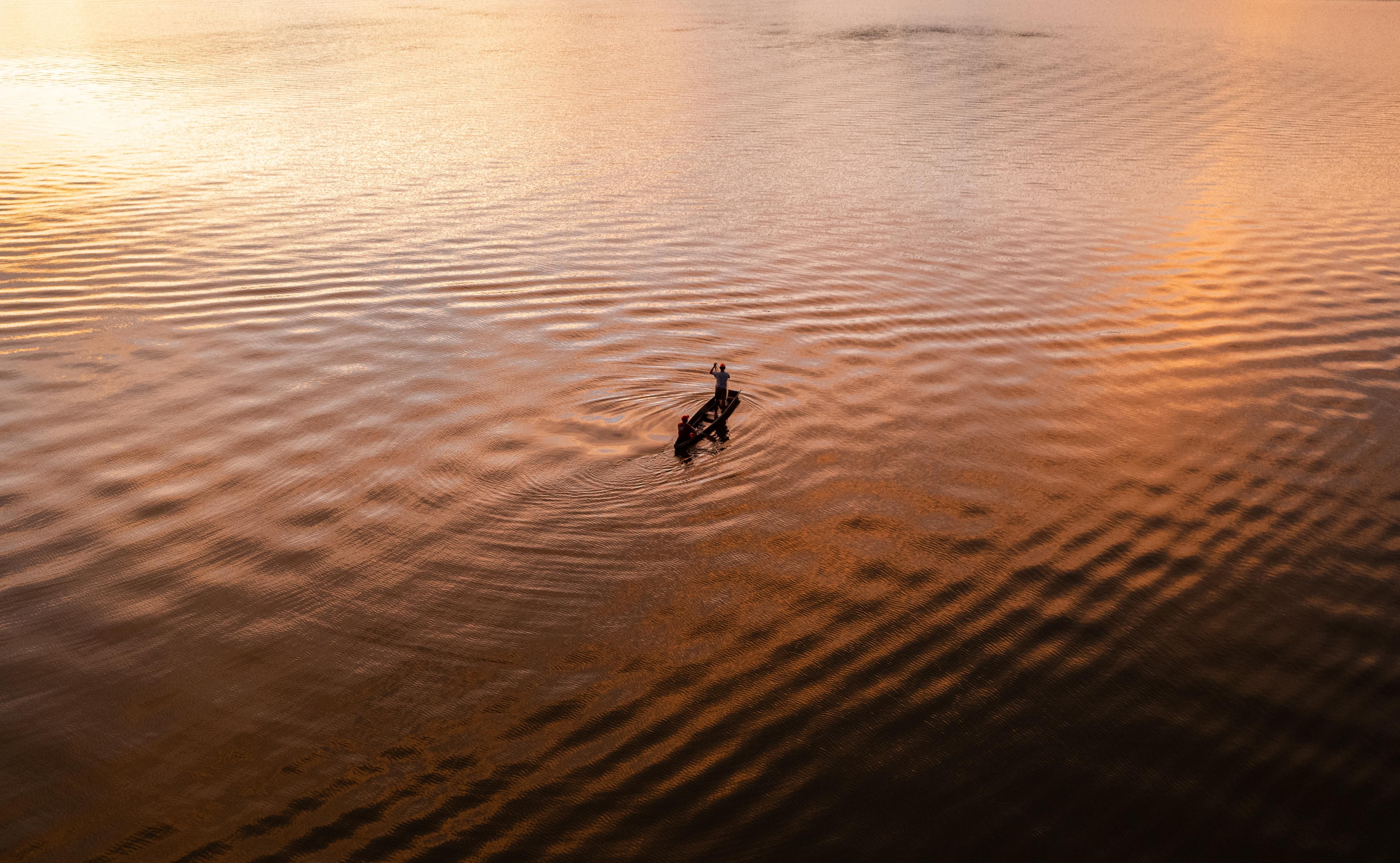 Silhouette of Men on a Boat in a Lake · Free Stock Photo