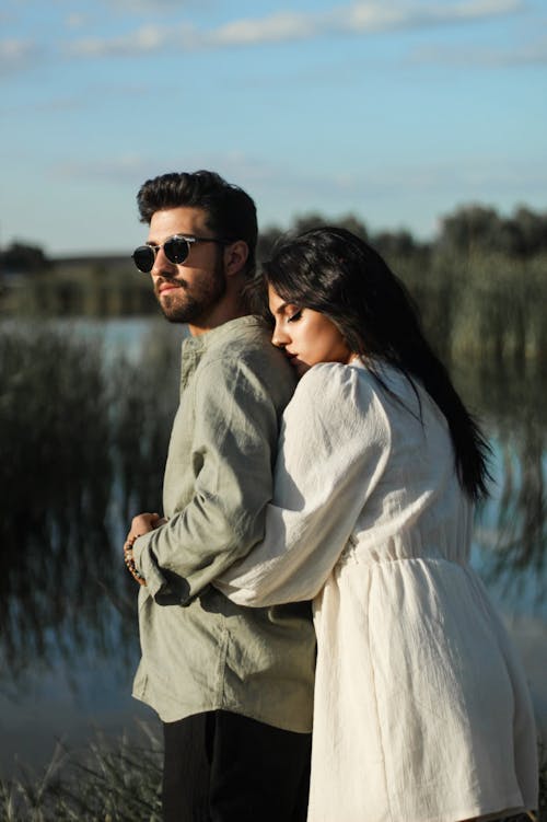 A Young Couple Standing Outside and Hugging 