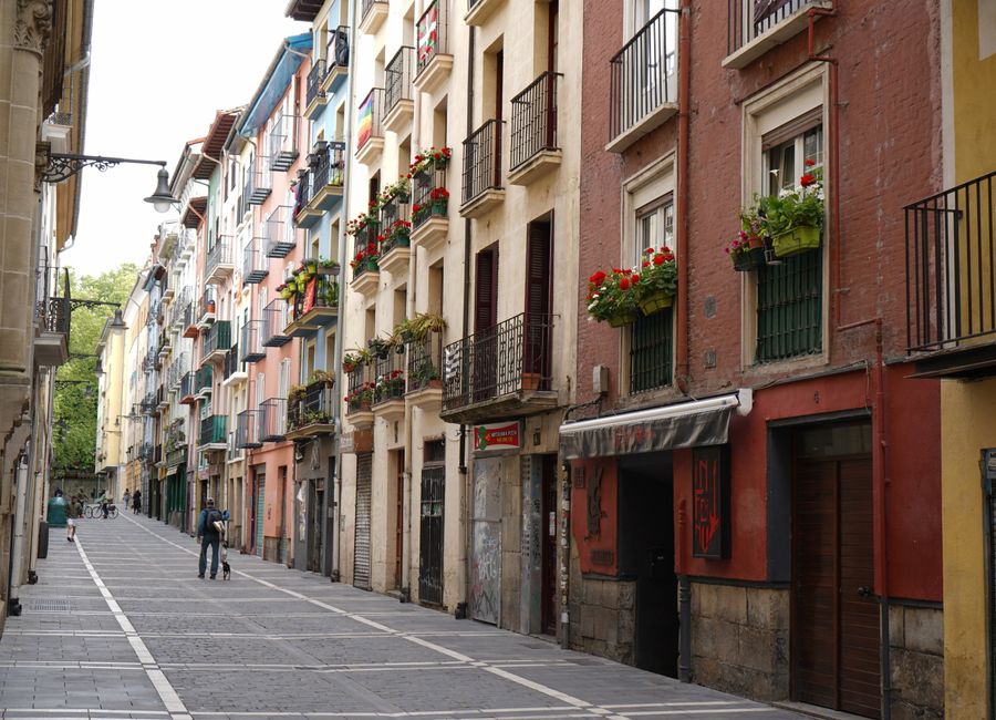 Explore a vibrant street in Pamplona, Spain, featuring a row of colorful residential buildings.