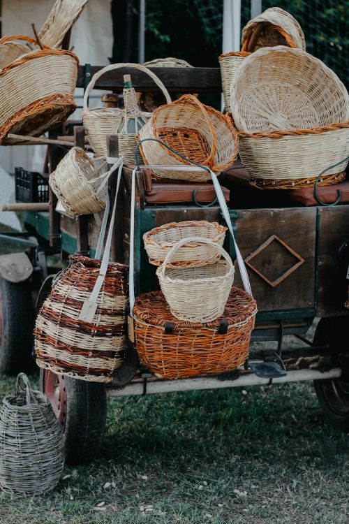 Free Collection of handmade woven baskets displayed on a rustic cart at an outdoor market. Stock Photo