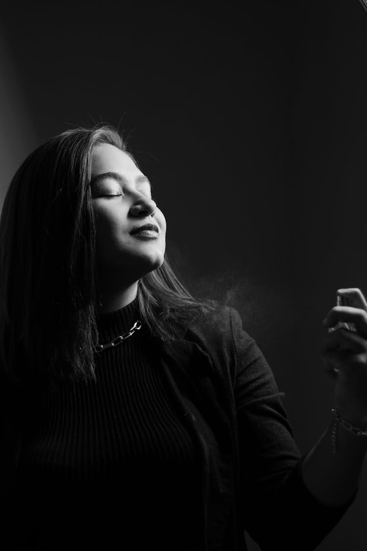 Woman Spraying Perfume In Black And White