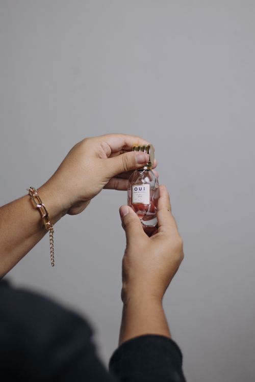 Free Aesthetic close-up of hands holding a glass perfume bottle with elegant design. Stock Photo