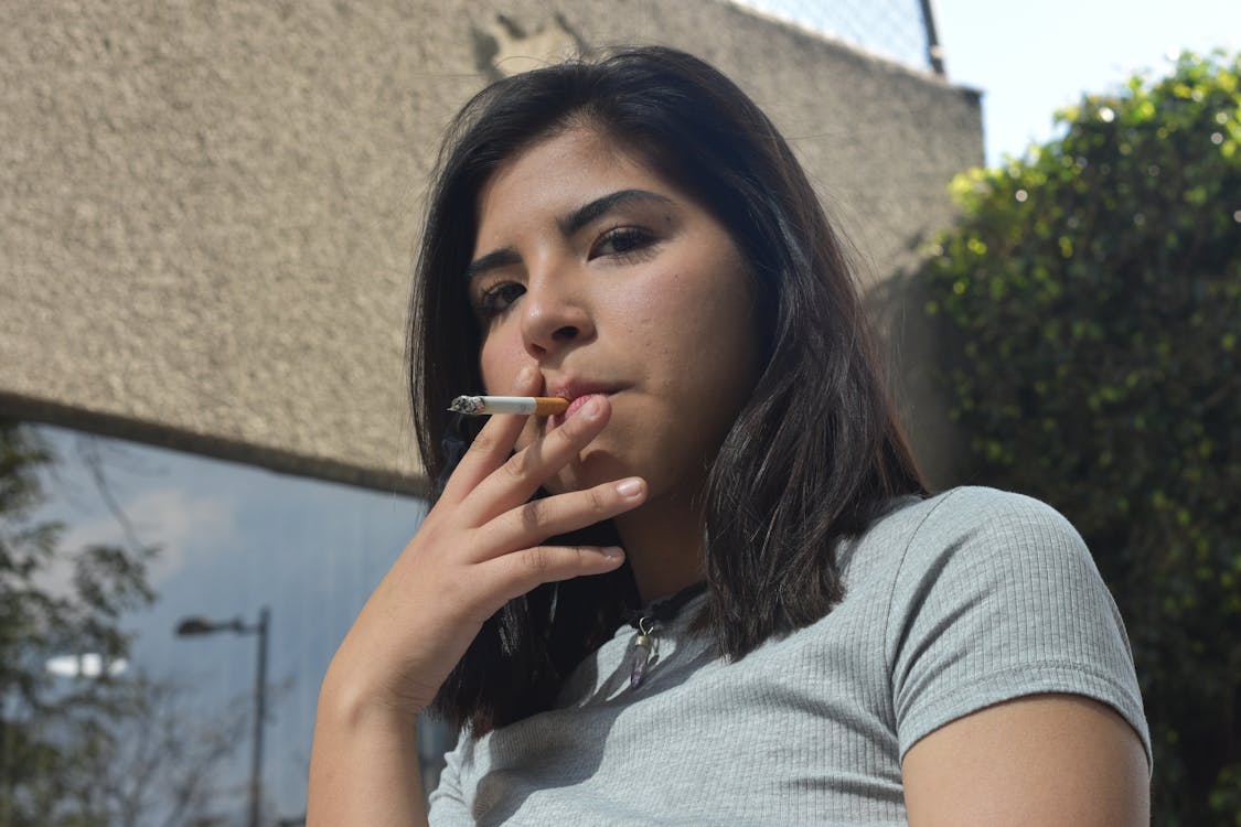Portrait of a Young Brunette Woman Smoking a Cigarette