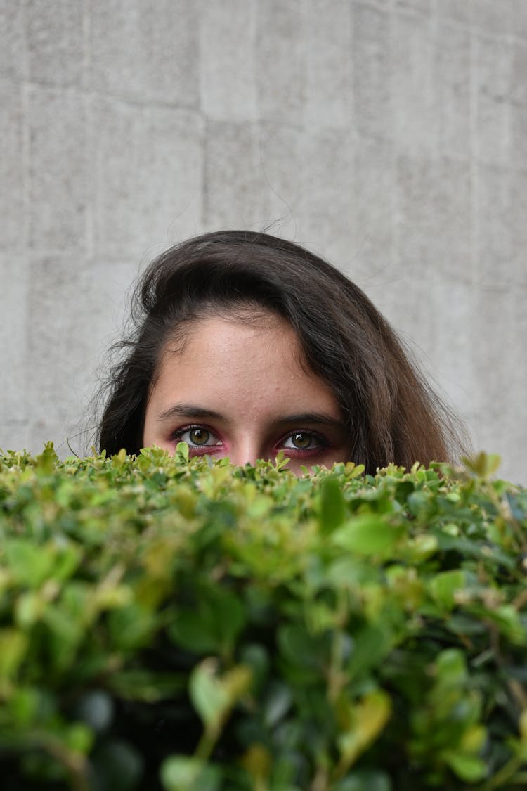 Woman Looking Behind Hedge