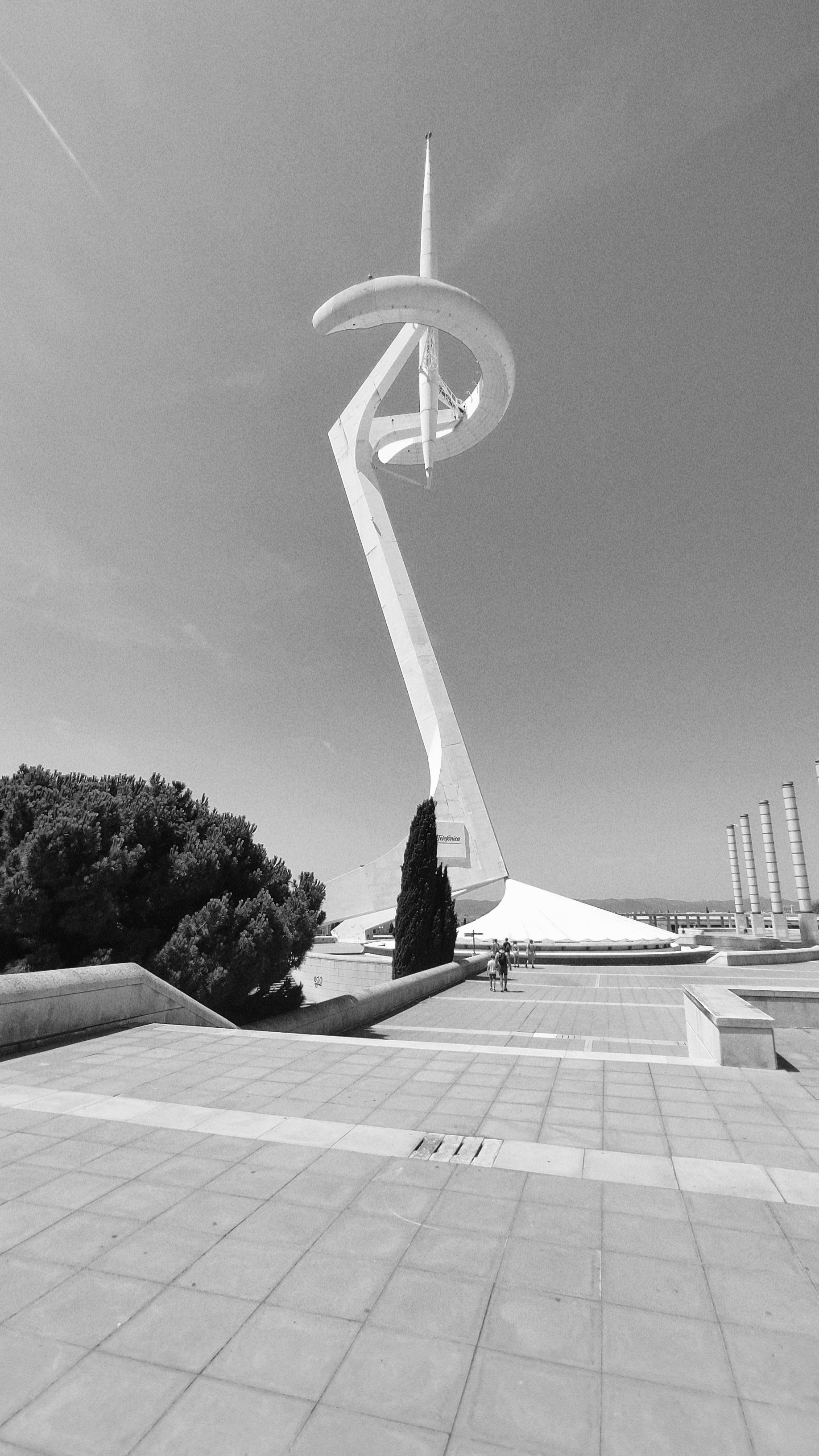 Black and white photo of the iconic Montjuïc Communications Tower in Barcelona, showcasing modern architecture.