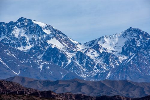 Free Majestic snowcapped mountain range with rocky peaks under a clear sky. Stock Photo