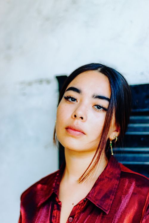 Free Close-up portrait of a woman with earrings, wearing a red jacket. Stock Photo