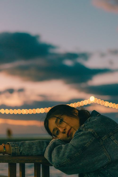 Resting On Railing Woman Resting on Wooden Railing on Sea Shore at Sunset · Free Stock Photo