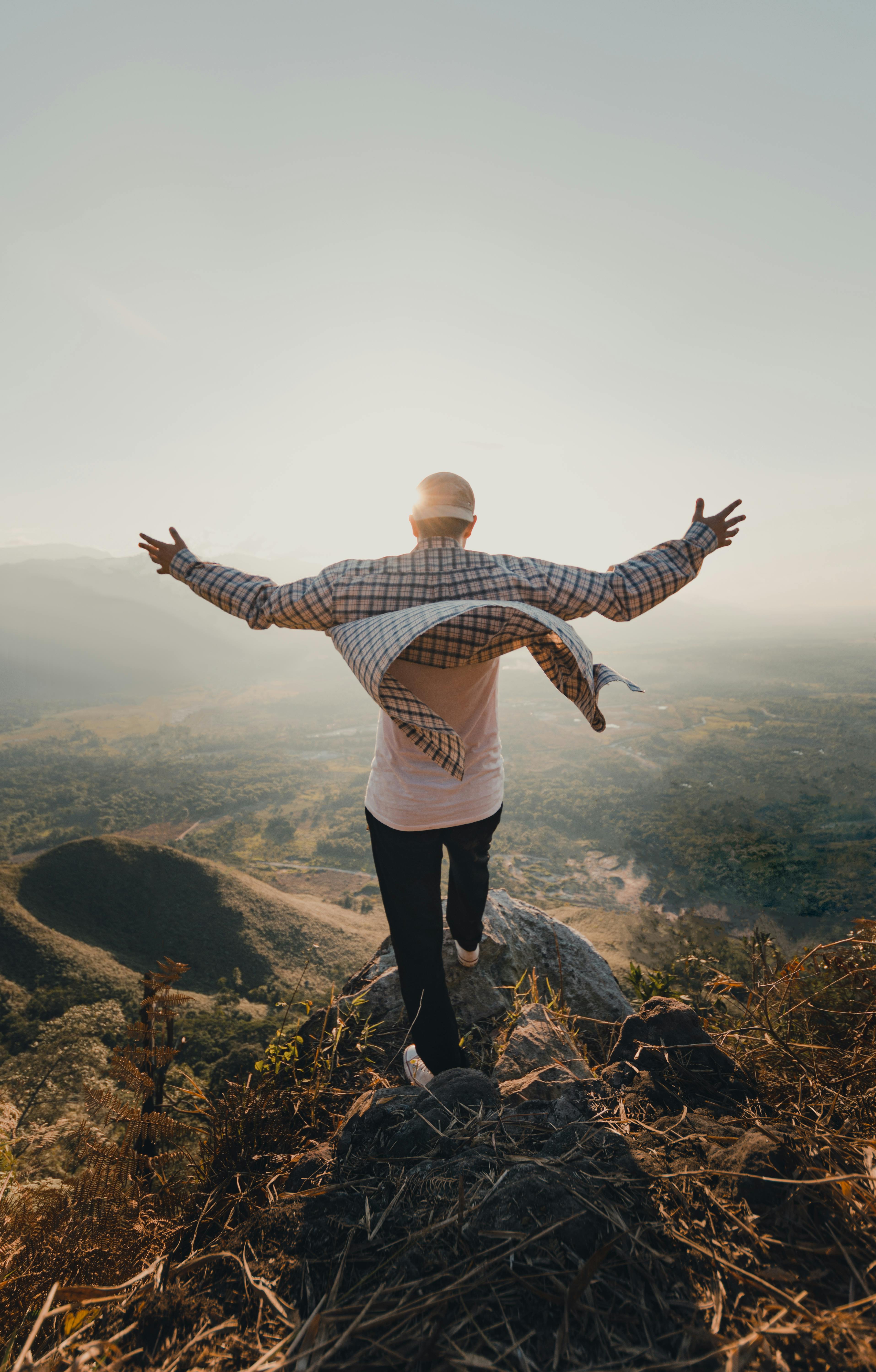 Man enjoying the serene view from a mountain peak in Rioja, Perú, symbolizing freedom and adventure.