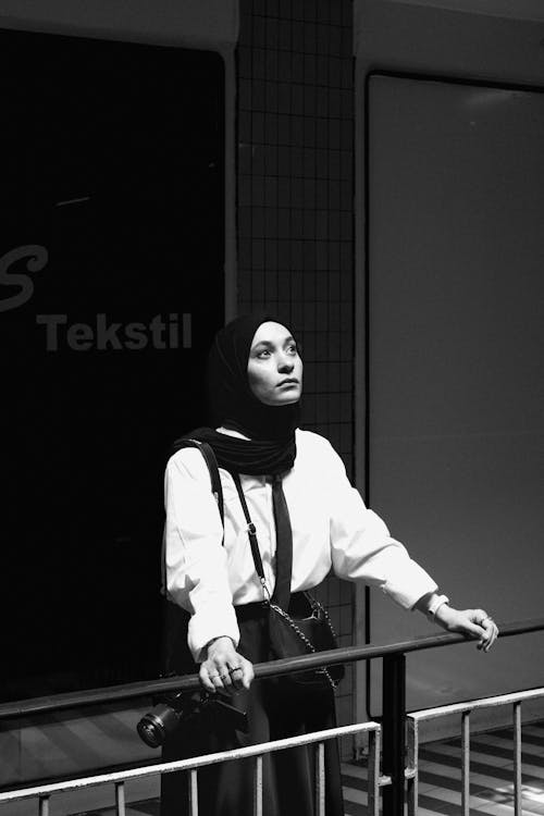 Woman with a Camera Standing and Leaning on the Railing 