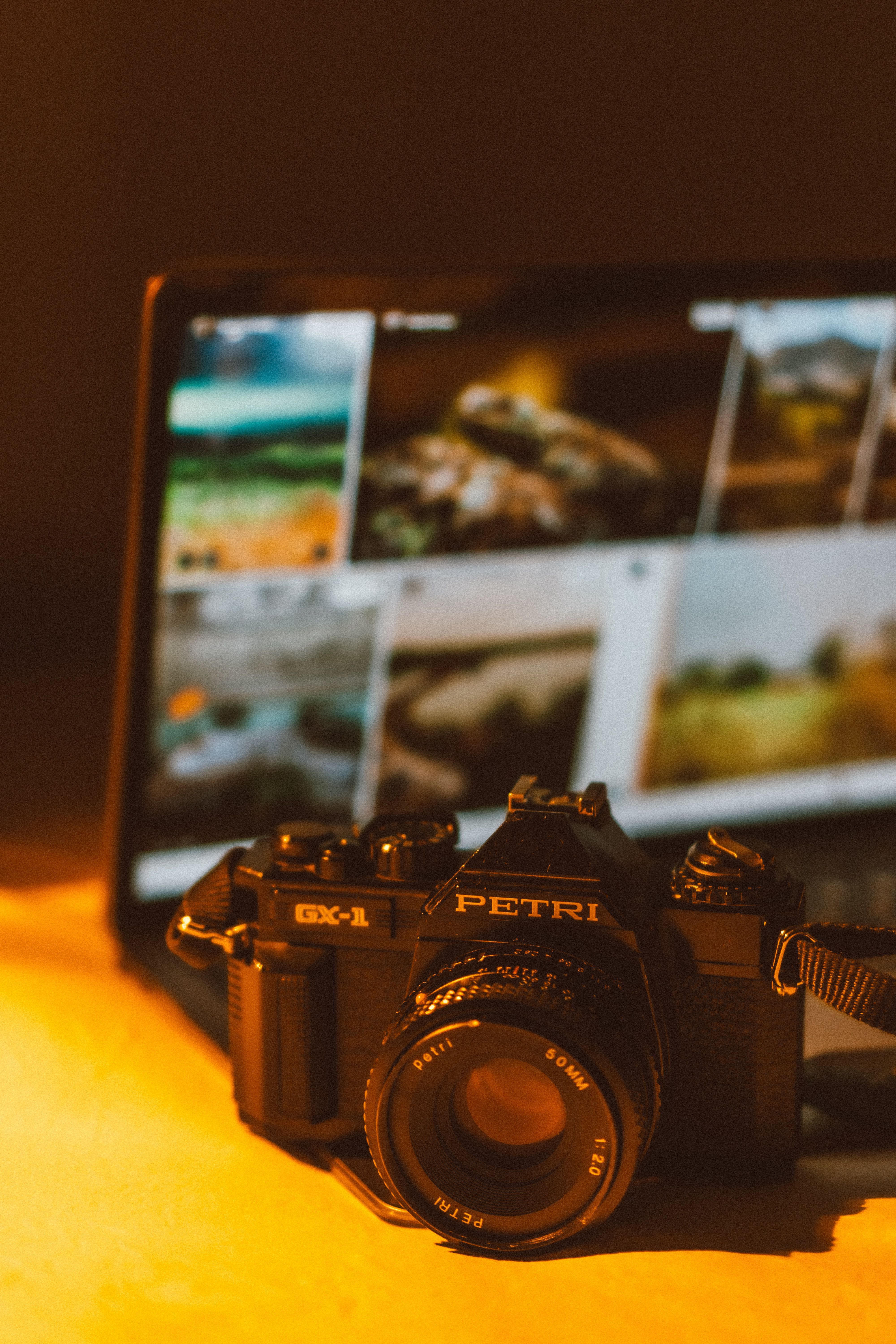 Artistic shot of a vintage camera with blurred digital images in the background. Perfect for themes of photography and nostalgia.