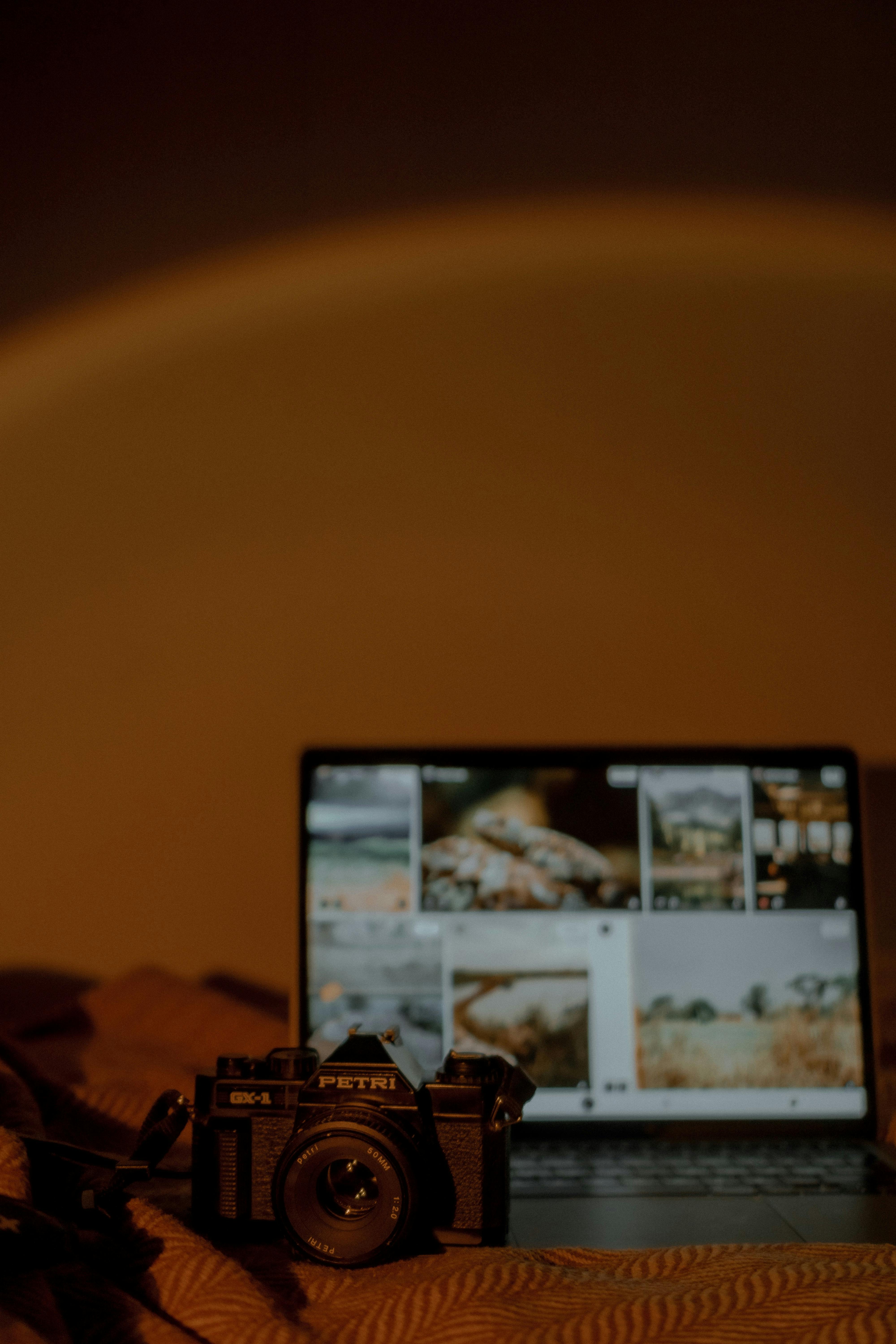 Camera Set on Bed Covers next to Laptop · Free Stock Photo