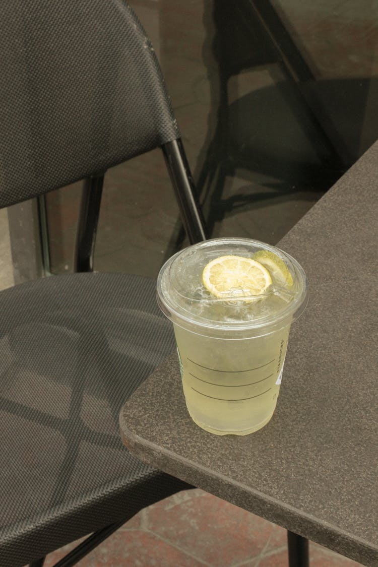 Lemonade In Takeout Cup Set On Edge Of Table