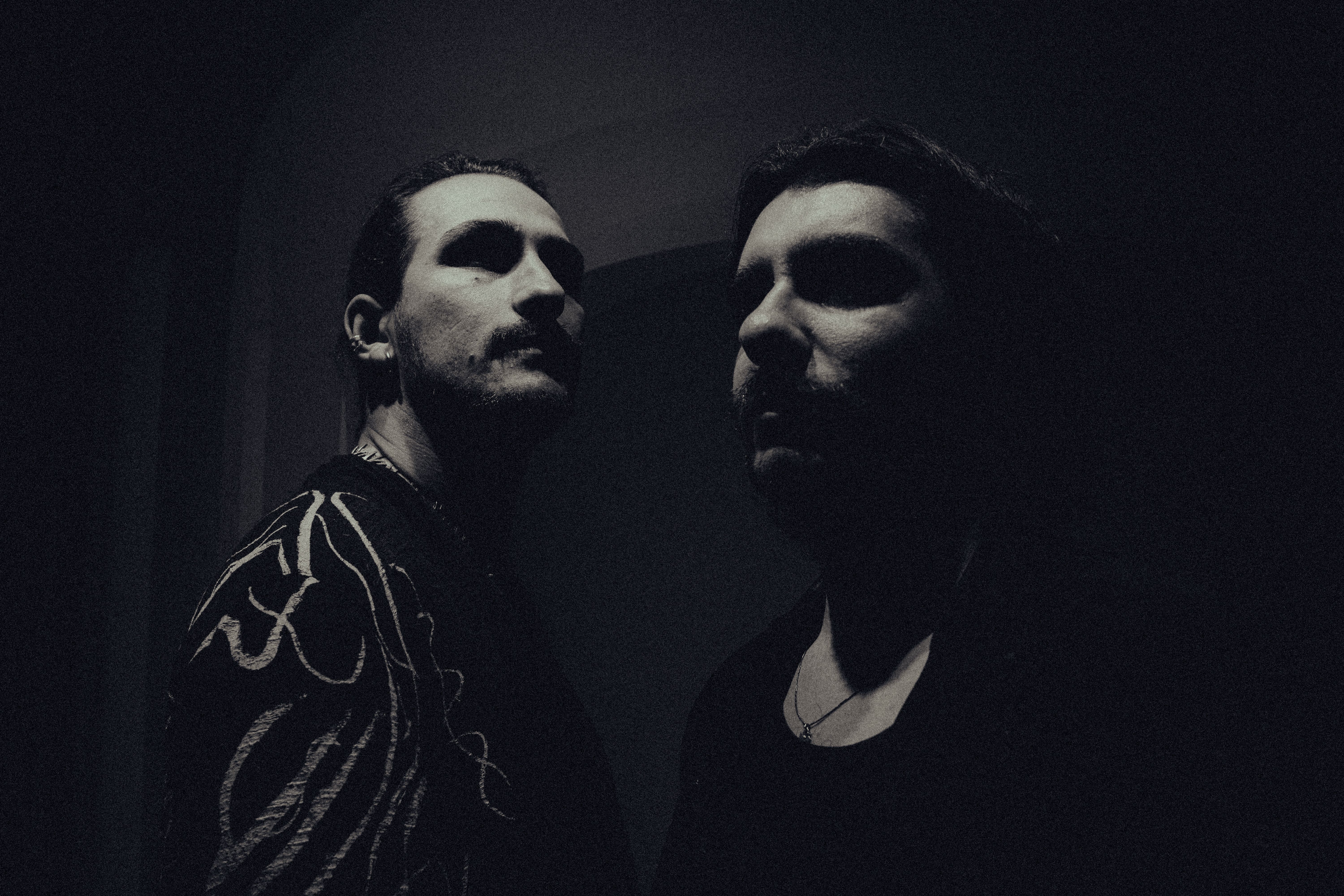 Dramatic black and white portrait of two men with intense expressions.